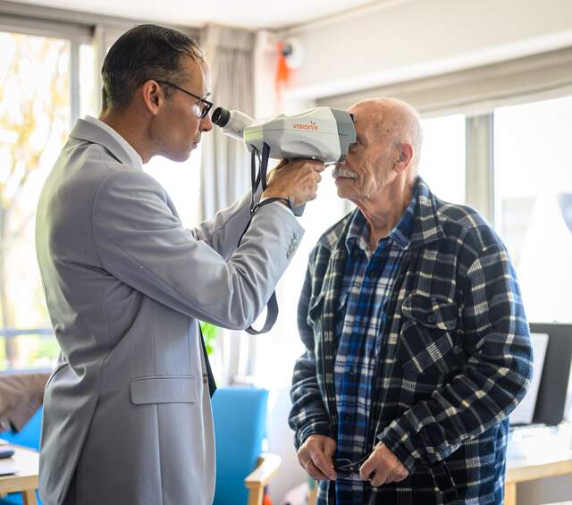 Twee mensen glimlachen in een oogzorglocatie.